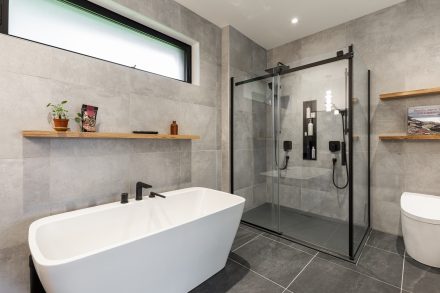 Interior of a modern bathroom with neutral tones featuring a separate bathtub and shower.